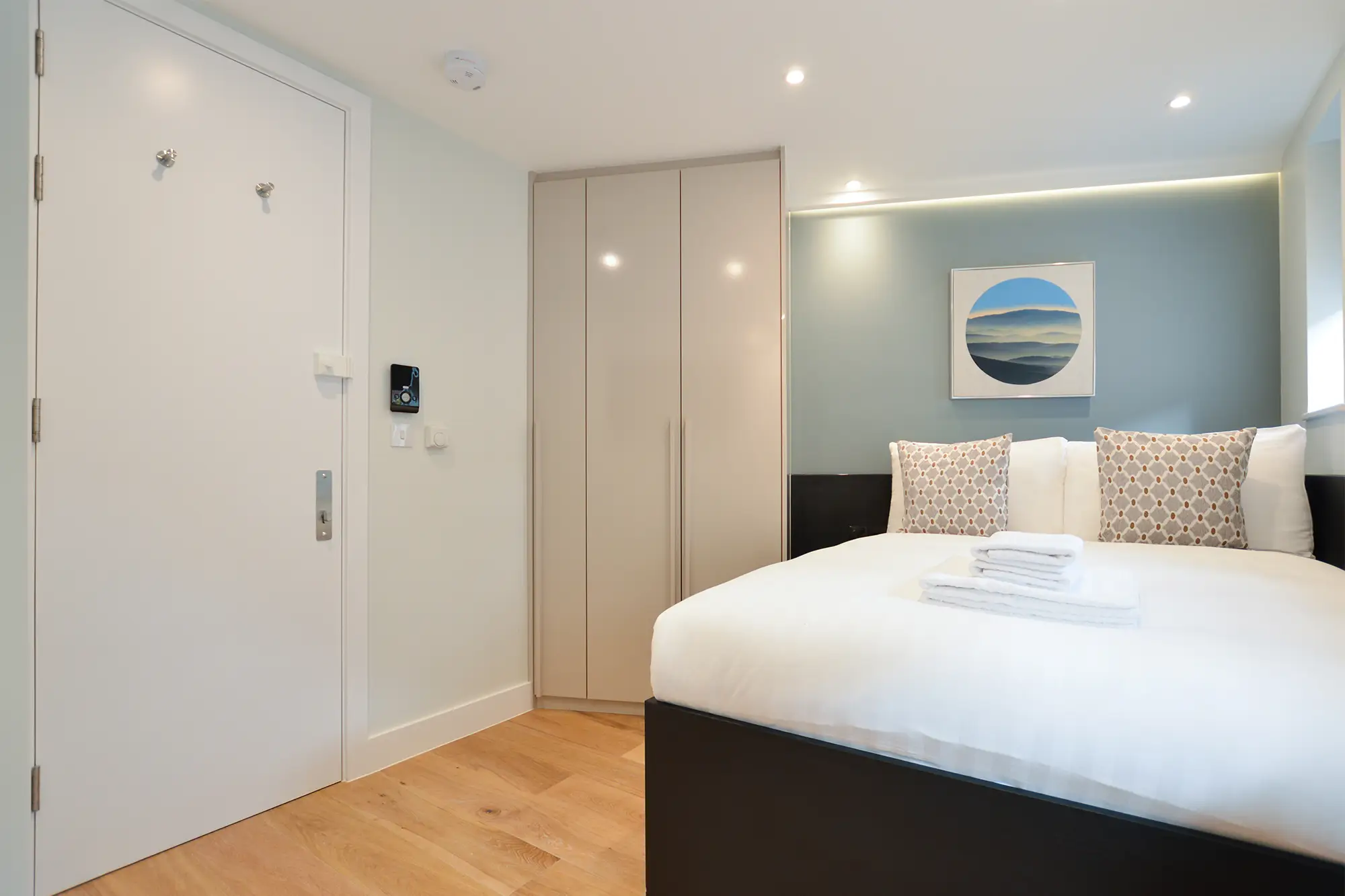 A luxurious double bed, a closet for ample storage, and hardwood floors with underfloor heating in a chic studio apartment at 162 New Cavendish St, Marylebone, Central London