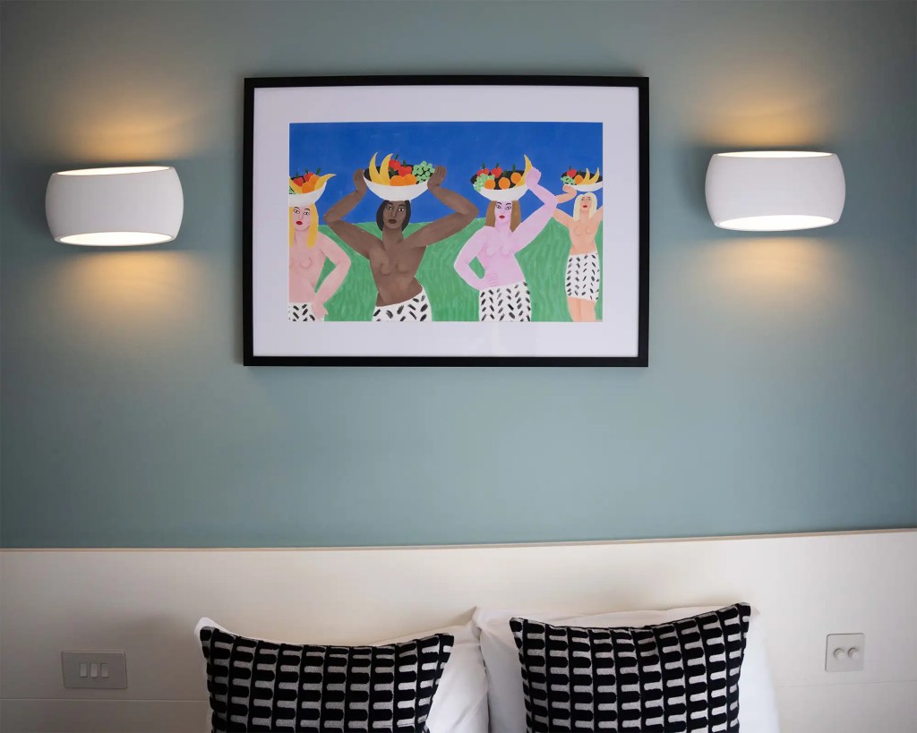 A stylish one-bedroom serviced apartment overlooking Portobello Road, Notting Hill, with a staircase leading to the upper level, a modern sleeping area with a plush double bed, wooden floors, underfloor heating, and an entrance to an elegant private bathroom with a shower