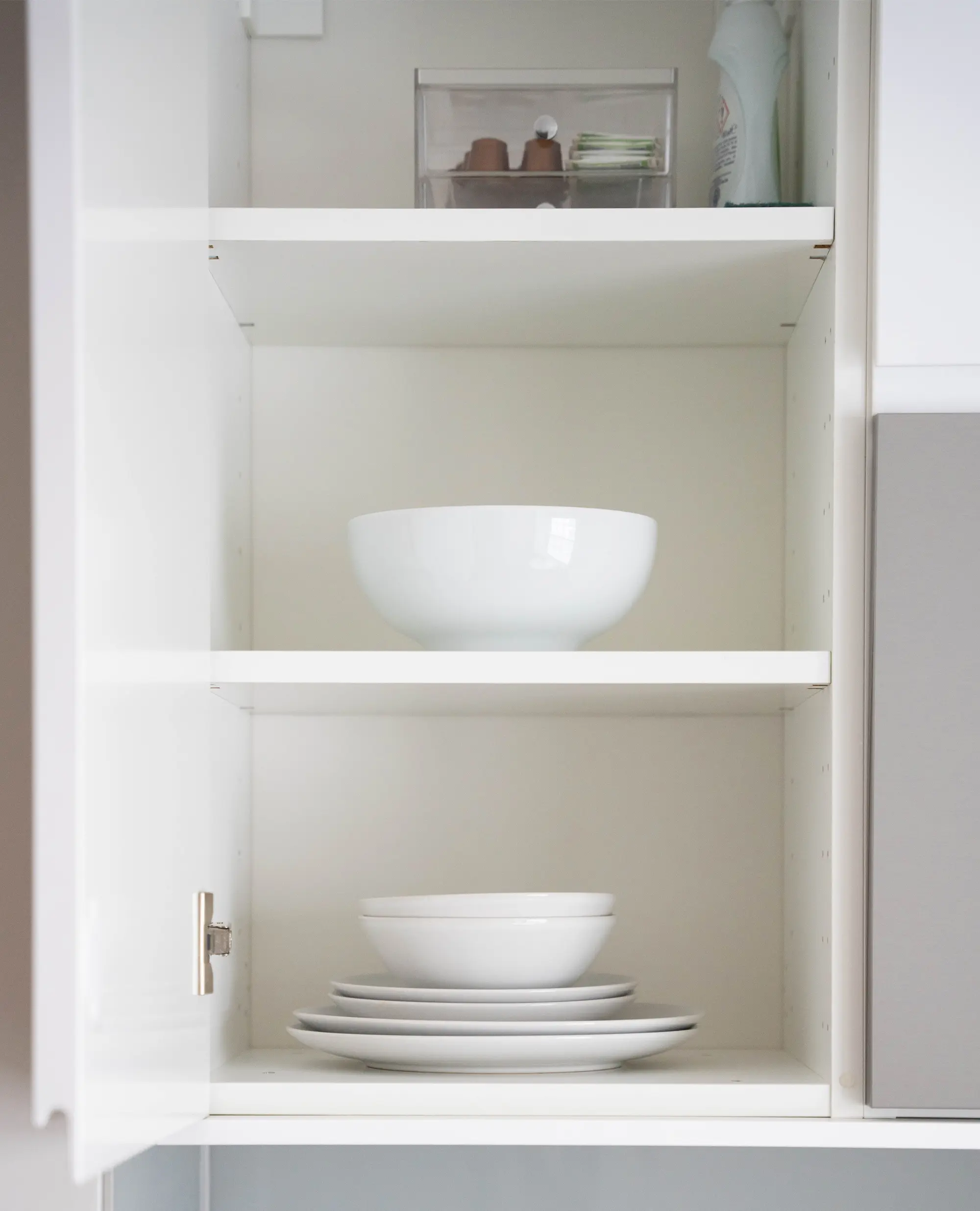 A fully equipped kitchen with bowls and plates neatly stored in cabinets at Stayprime serviced apartments in central London