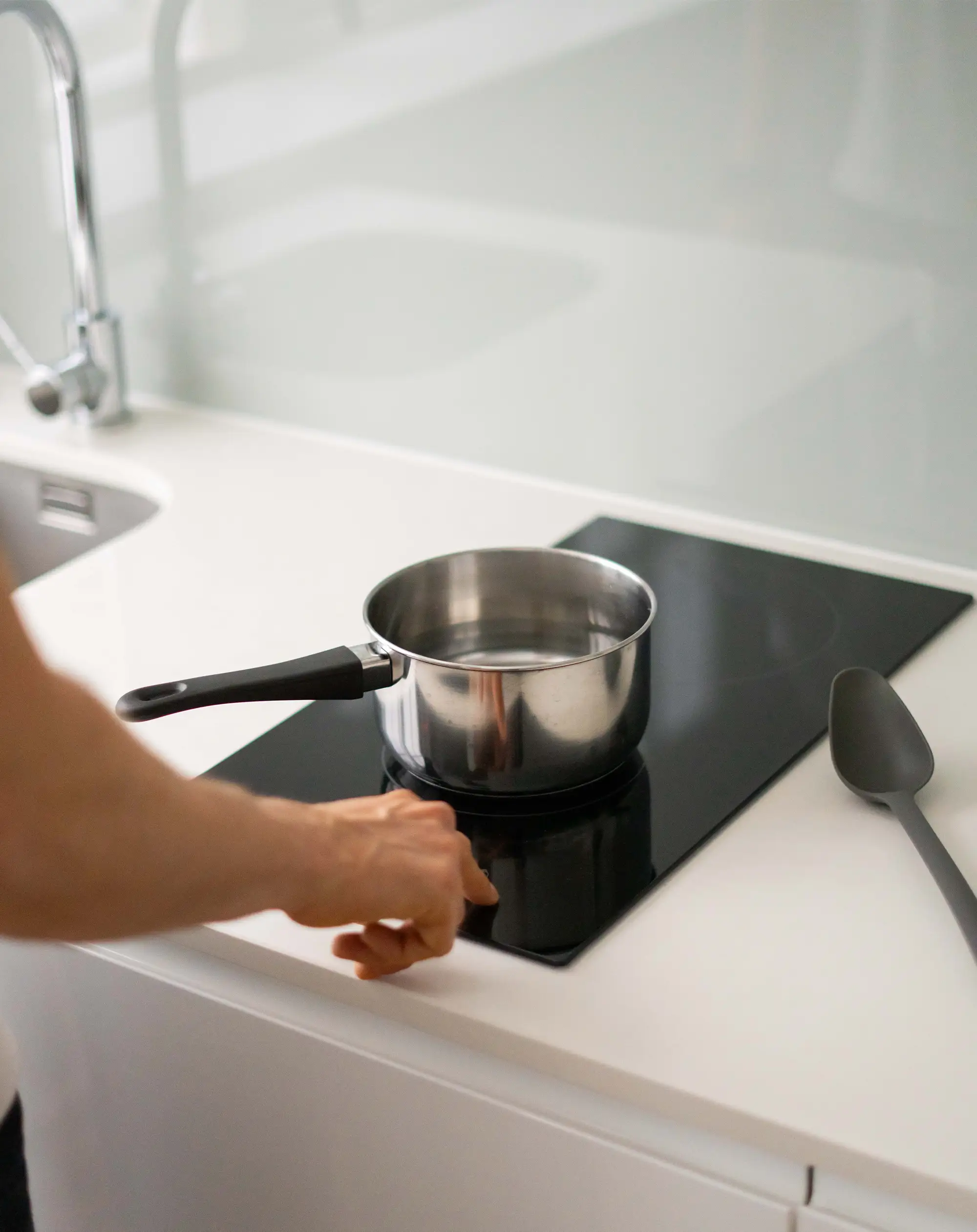 A young professional enjoying cooking in a fully equipped kitchenette at Stayprime serviced apartments, offering the perfect blend of comfort and convenience