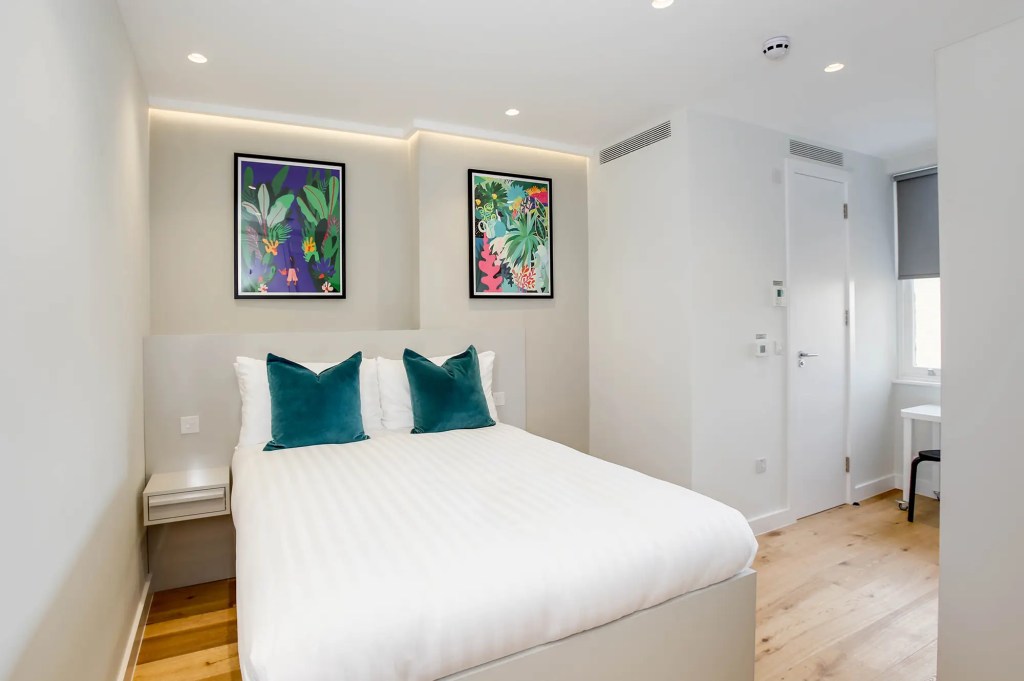 A cozy sleeping area and wardrobe space in a studio apartment at 3 Knaresborough Place, Kensington, London