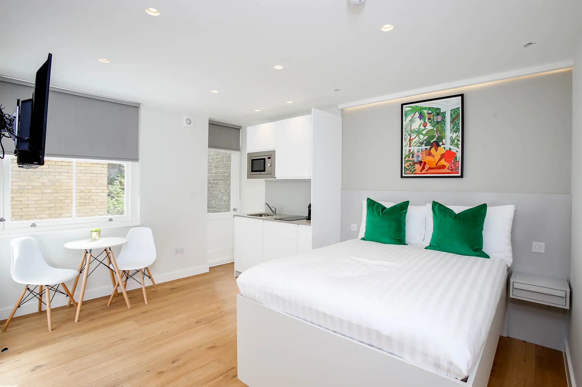 An airy studio apartment with a double bed and fully equipped kitchen area in Cromwell serviced apartments in London