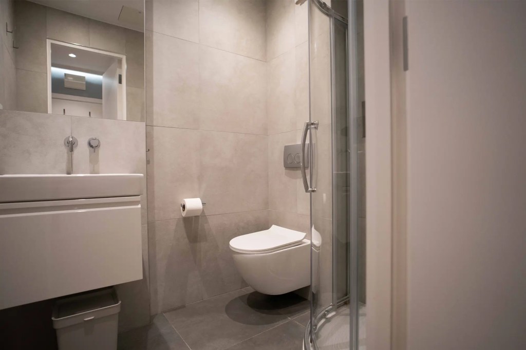 A comfortable sleeping area and a TV in a one-bedroom flat at 3 Knaresborough Place, Kensington, London