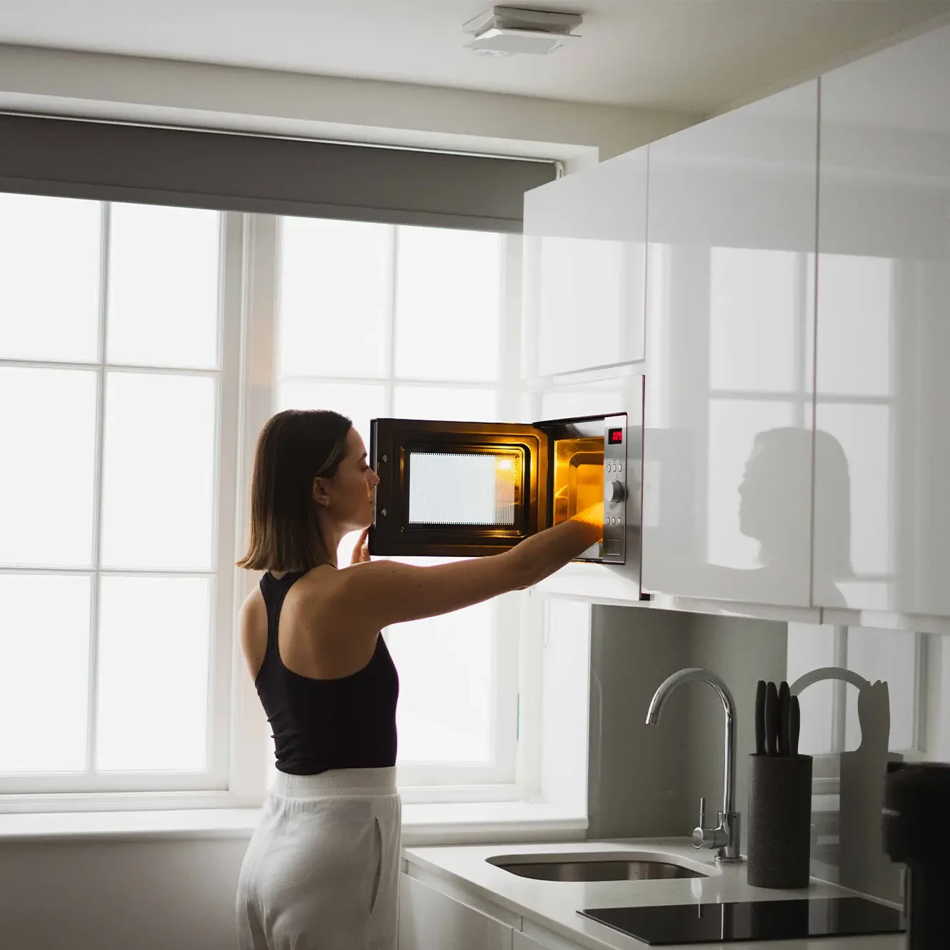 A young professional preparing a meal in a fully equipped kitchenette at Spacpiues Marylebone large studio in 162 New Cavendish, London