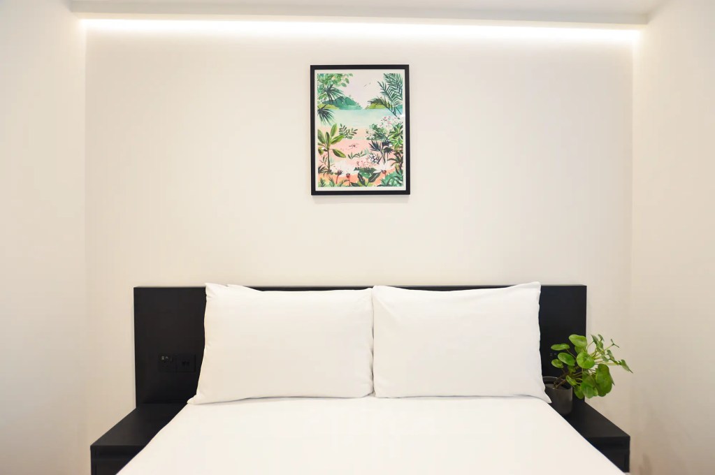 A comfortable double bed and light-filled window in a small one-bedroom apartment in Marylebone at 162 New Cavendish, London