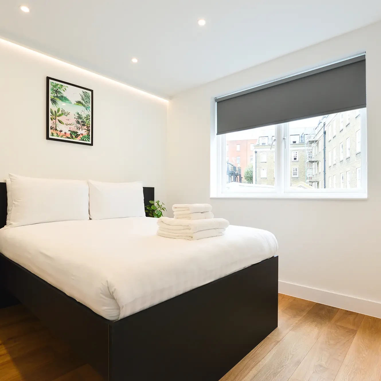 A comfortable double bed and light-filled window in a small one-bedroom apartment in Marylebone at 162 New Cavendish, London