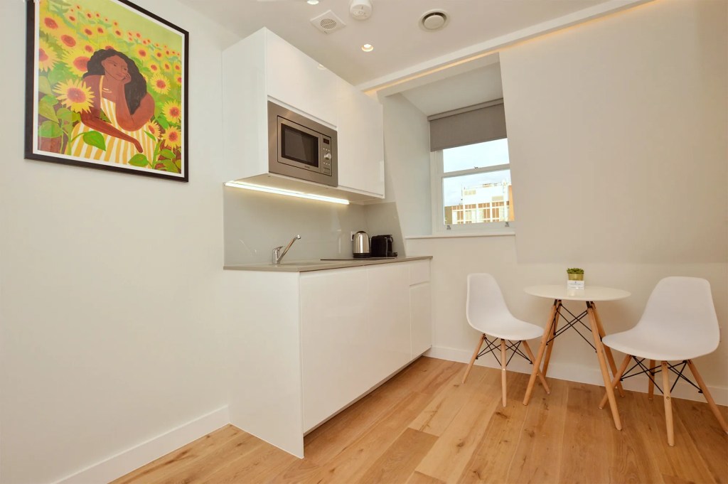 A comfortable sleeping area and a TV in a one-bedroom flat at 3 Knaresborough Place, Kensington, London