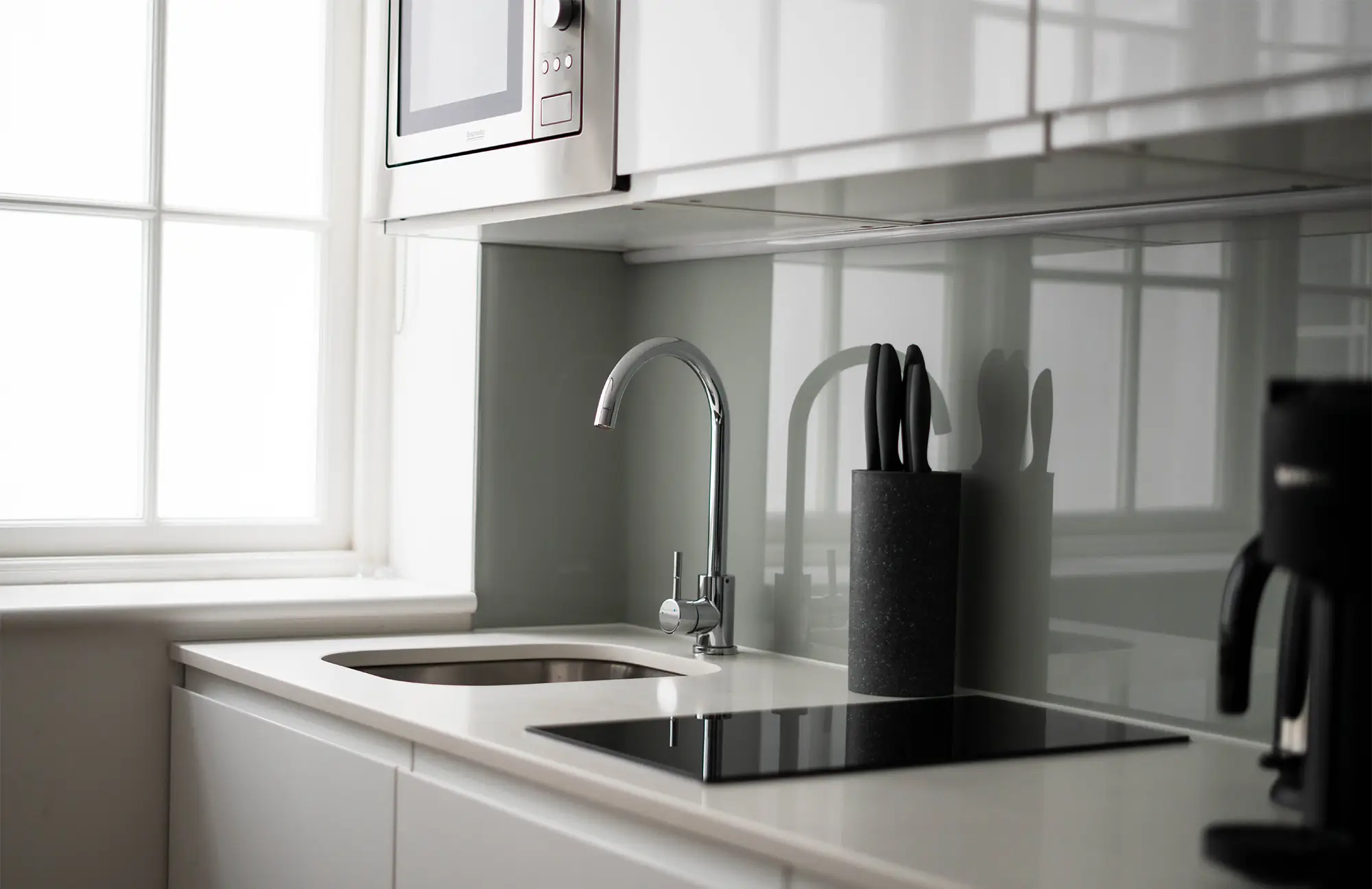 Stylish, fully equipped kitchenette near large windows that flood the spacious Marylebone studio apartment with natural light