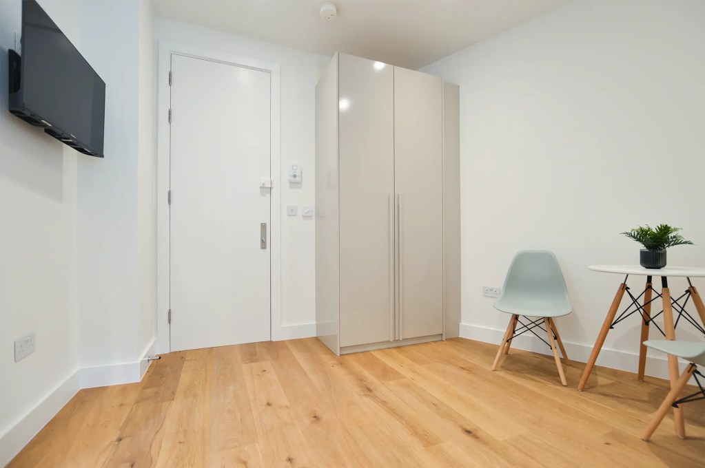 A comfortable double bed and light-filled window in a small one-bedroom apartment in Marylebone at 162 New Cavendish, London