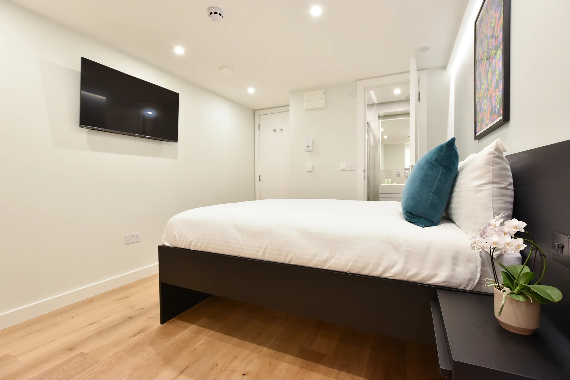 Comfortable double bed and sleek television in spacious corporate serviced apartment in Earls Court—your affordable stay for short-term rentals in London with Stayprime.
