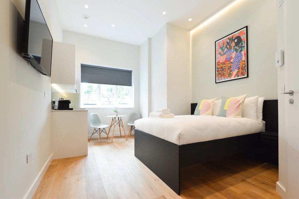 Comfortable double bed with an elegant dining area and fully equipped kitchen in a cozy Earls Court studio apartment, perfect for a convenient and stylish stay in London
