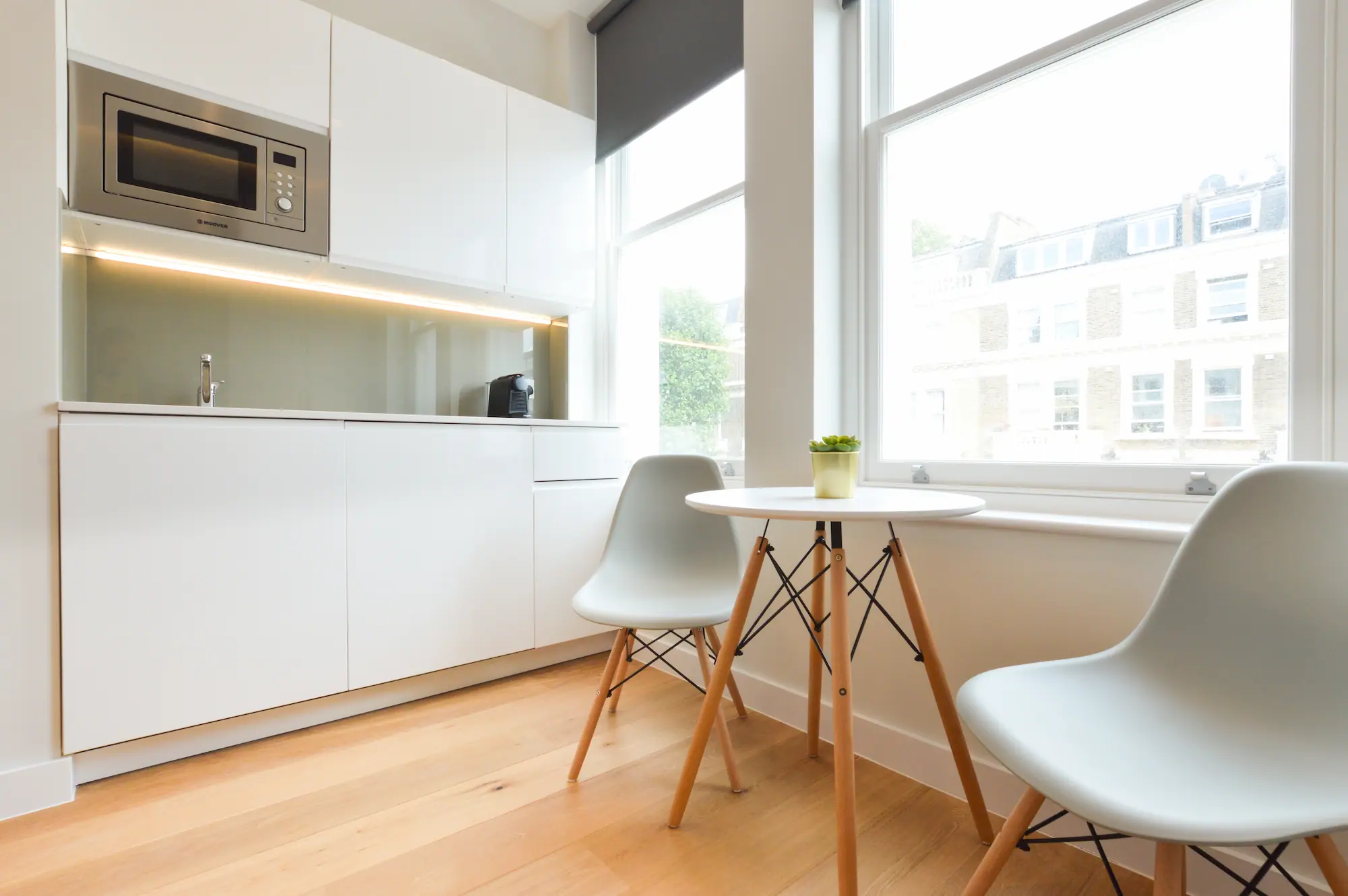 An elegant, fully equipped kitchenette with dining area in a single room apartment at Penywern Road Stayprime short let flats in Earls Court