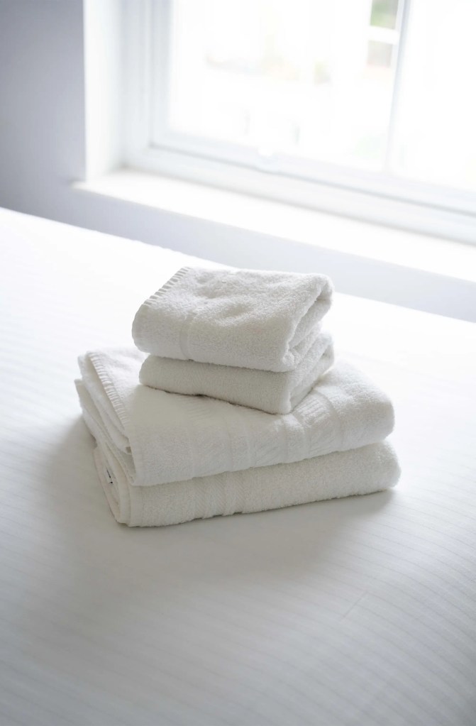 Complimentary fresh, clean towels awaiting on a comfy double bed in a stylish serviced apartment in Central London