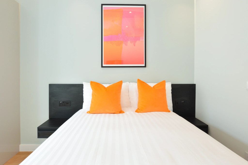 Stylish wall decor and a comfortable double bed in a single-room apartment in Earl's Court, London