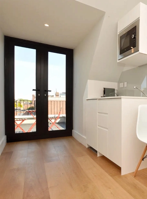 A bright top floor one bedroom long-term let studio in Notting Hill with a terrace and a practical, fully equipped kitchen