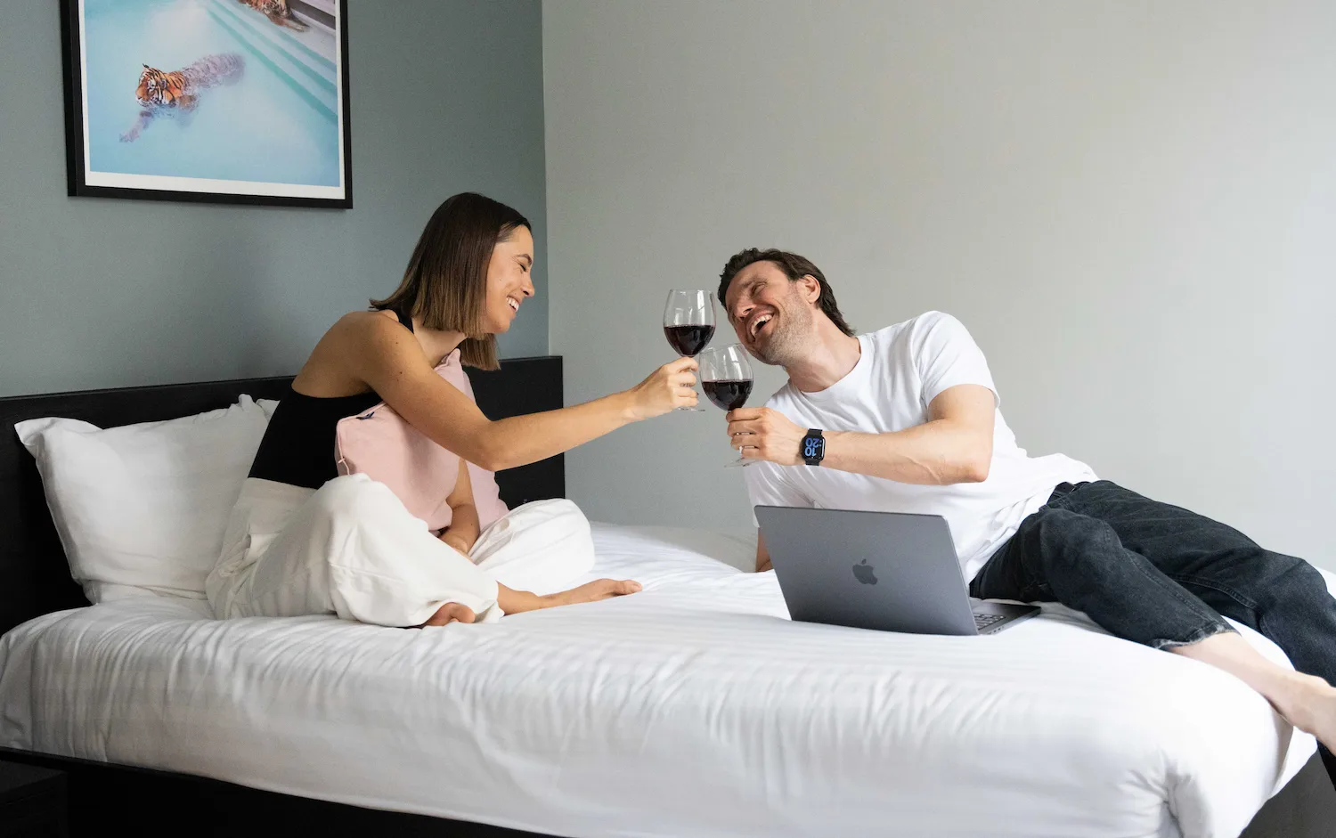 A young couple enjoying a double bed in an affordable serviced apartment studio in London.
