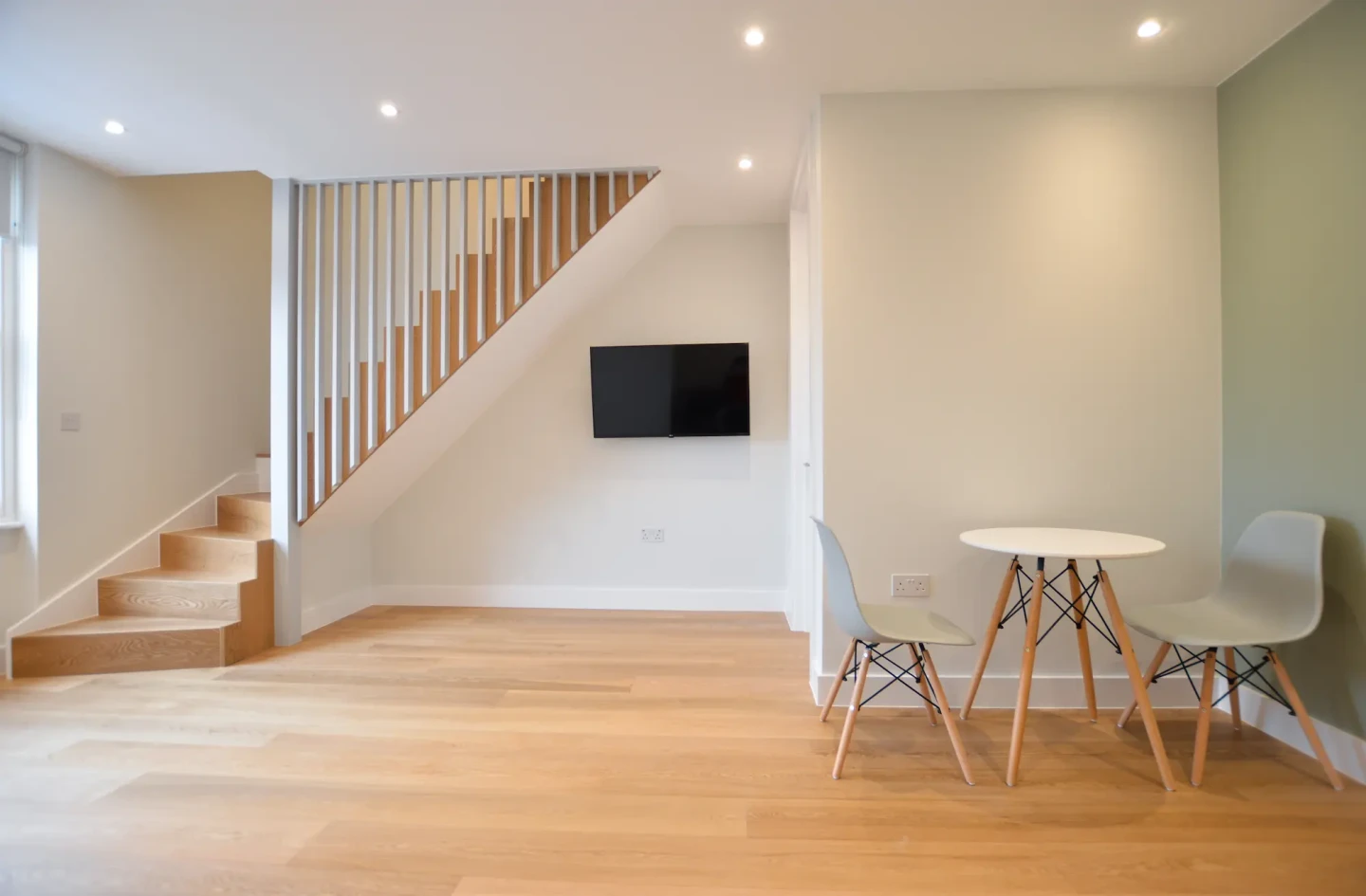 Bright and spacious one bedroom apartment in Central London with wooden floors, a TV unit, and a dining area at Stayprime Serviced Apartments.
