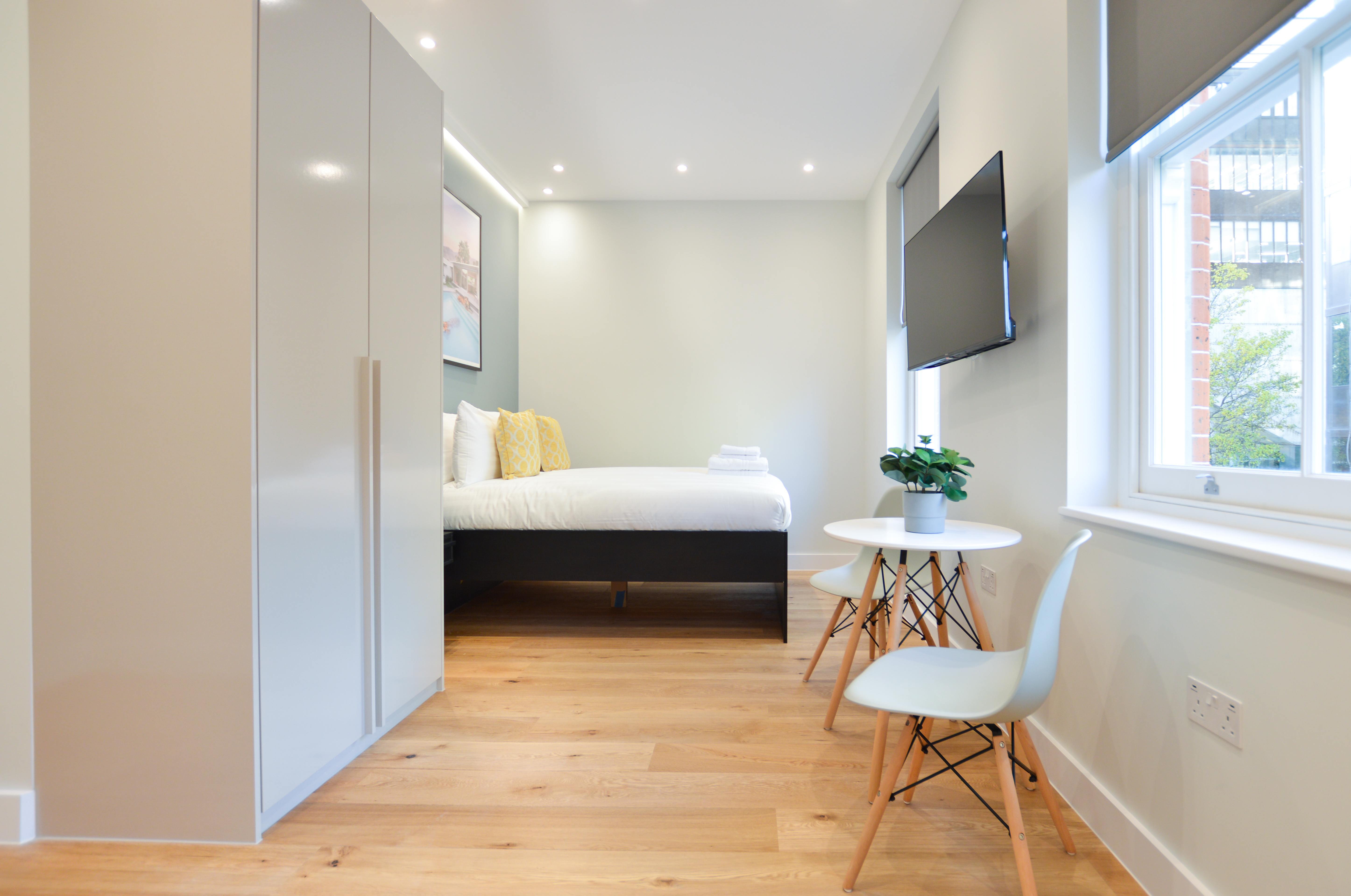 A modern, fully furnished long term let in Marylebone, London, with a double bed, wooden floors, and a dining area