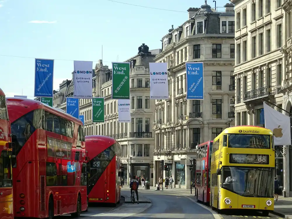 ed double-decker buses travelling through Central London city streets